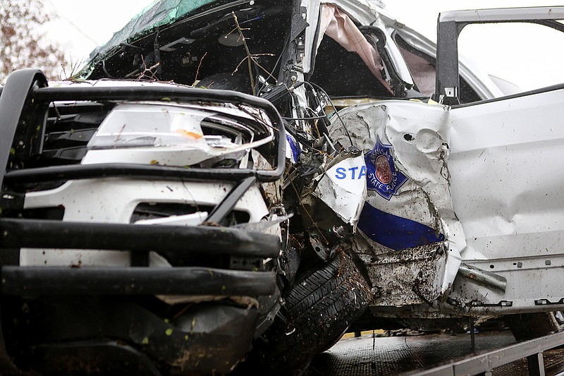 Arkansas state trooper Cpl. Clayton McWilliams' A Troop G vehicle sits on the back of a tow truck after hydroplaning and striking a tree on the side of U.S. Highway 71 on Thursday near Wilton, Ark. The state trooper was pinned inside of the vehicle until local fire departments arrived on the scene and was then transported to CHRISTUS St. Michael Health System. He has since been moved to a Little Rock hospital.