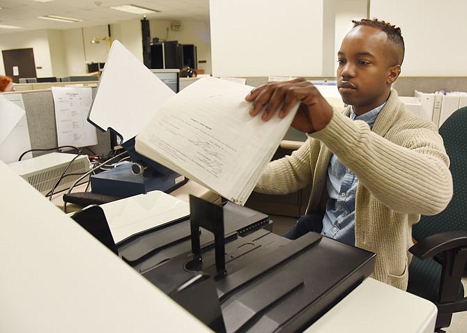 Xavier Jordan runs the Kodak scanner in the imaging department of Records Management in the Secretary of State's office. Jordan, who has worked at this job for a year, enjoys the variety of items he scans in a day's time. These particular documents are death certificates from 1968.
