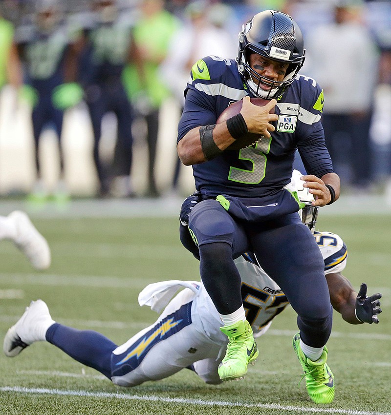 In this Nov. 4, 2018, file photo, Seattle Seahawks quarterback Russell Wilson (3) tries to get past Los Angeles Chargers' Jatavis Brown during the second half of an NFL football game, in Seattle. Russell Wilson won a playoff game with Seattle as a rookie, a Super Bowl in his second season and another NFC championship the third time around.
The best Dak Prescott can hope for with the Dallas Cowboys is to join Wilson on that list of Super Bowl winners in his third year, a quest that will start with the first postseason meeting of quarterbacks with quite a bit in common, other than postseason pedigree.(AP Photo/Scott Eklund, File)