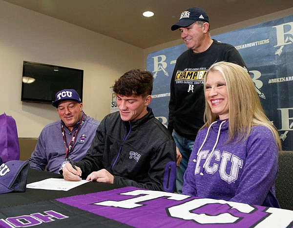 In this Dec. 19, 2018, file photo, Broken Arrow football player Zach Marcheselli, with his dad Vincent, mom Rayvonne and coach David Alexander, smile as he signs with TCU during a national signing day event in Broken Arrow, Okla.