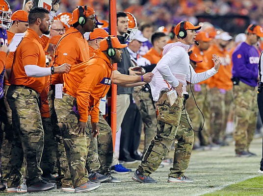 Clemson defensive coach Brent Venables is pulled back by an assistant during a game this season in Clemson, S.C. Venables coaches his oldest son, Jake, a linebacker.