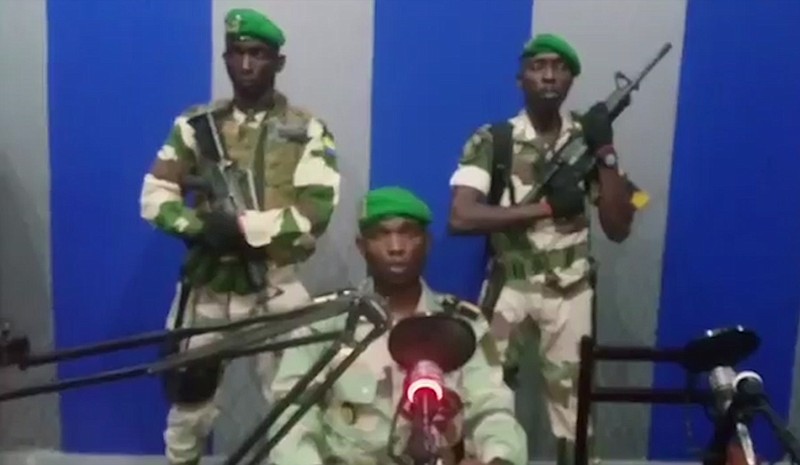 In this image from TV, a soldier who identified himself as Lt. Obiang Ondo Kelly, commander of the Republican Guard, reads a statement on state television broadcast from Libreville, saying the military has seized control of the government, Monday Jan. 7, 2019.  The statement said Soldiers from Gabon's Republican Guard have launched a coup "to restore democracy" in the West African country, while imposing a curfew in the capital, and the internet has been cut.  No violence has been reported and President Ali Bongo has been out of the country since October amid reports that he had a stroke.(Gabon State TV via AP)