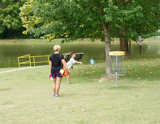 During his first disc golf tournament, Princeton Miller, 11, participates in a past tournament at Veterans Park in Fulton with the support of his mother, Theresa. "I get to play with my cousins, too," he said.