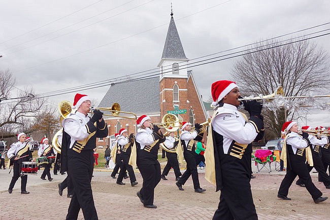 Wearing golden capes, members of the Fulton High School marching band strut down Fifth Street during the 2018 Christmas parade. Locals lining the streets waved to their friends and family.