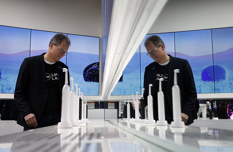Hansjoerg Reick looks at a display of Oral-B Genius X smart toothbrushes at the Procter & Gamble booth before CES International, Monday, Jan. 7, 2019, in Las Vegas. (AP Photo/John Locher)