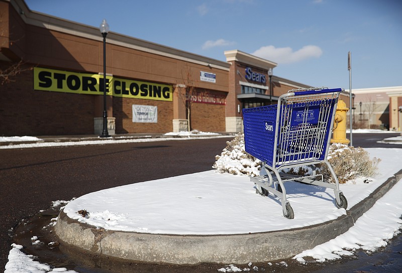 FILE- In this Tuesday, Jan. 1, 2019, file photo, an empty shopping cart sits in the snow outside a Sears store in the Streets of Southglenn mall in Littleton, Colo. Sears is getting another reprieve from liquidation after its chairman and largest shareholder revised his bid to save the iconic brand. The Hoffman Estates, Illinois-based retailer says it has accepted Eddie Lampert's bid through an affiliate of his ESL hedge fund that could keep 425 stores open and save tens of thousands of workers, according to a hearing on Tuesday, Jan. 8, 2019, at the bankruptcy court in White Plains, N.Y. (AP Photo/David Zalubowski, File)