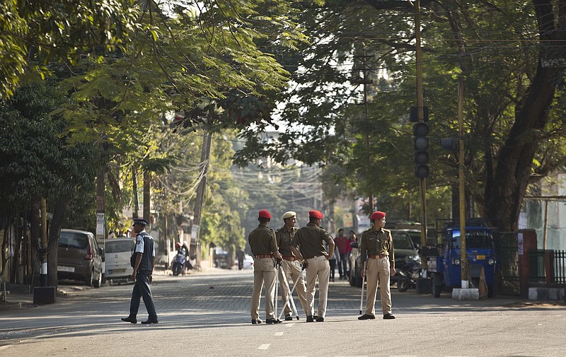 Indian police officials stand leisurely on a deserted road during an eleven hour general strike called by All Assam Students' Union (AASU) and North East Students' Organization (NESO) in Gauhati, India, Tuesday, Jan. 8, 2019. India’s populous northeast has experienced a near-total shutdown with sporadic incidents of violence to protest a bill introduced in Parliament to grant citizenship to non-Muslim migrants fleeing persecution in Pakistan, Afghanistan and Bangladesh. (AP Photo/Anupam Nath)