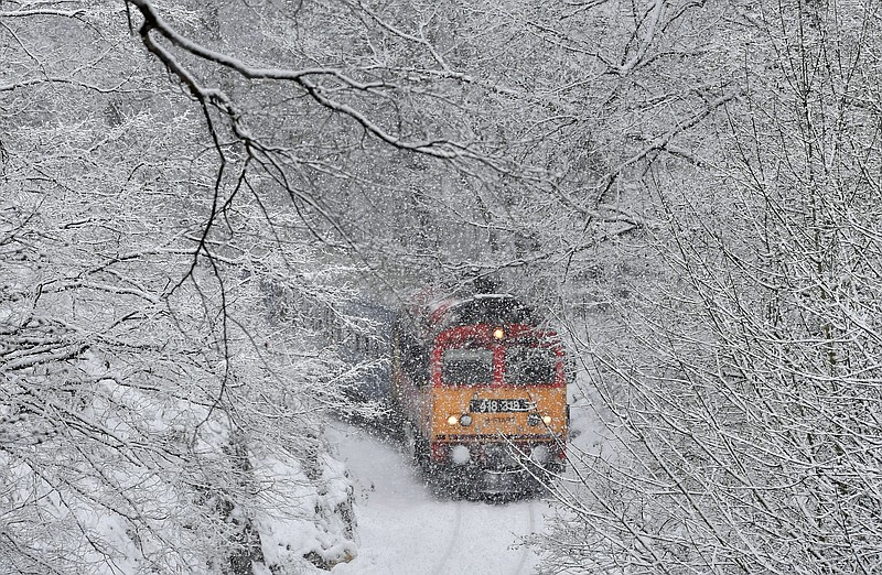 A passenger train crosses the Cuha Valley in the heavy snowfall near Vinye, some 140 km west of Budapest, Hungary, Tuesday, Jan. 8, 2019. (Zoltan Mathe/MTI via AP)