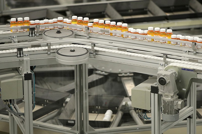 FILE - In this July 10, 2018 file photo, bottles of prescription medicines ride on a conveyor belt at a pharmacy warehouse in Florence, N.J. According to a report released on Tuesday, Jan. 8, 2018, annual spending by the U.S. health industry on ads and promotions has reached $30 billion. That includes advertisements for prescription drugs that were shown 5 million times on TV and elsewhere in 2016. That’s a huge increase in 20 years and just part of broad health industry efforts to promote drugs, devices, lab tests and even new hospitals. (AP Photo/Julio Cortez, File)