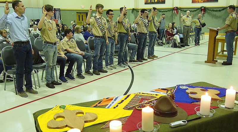 Five Boy Scouts of Troop 47 sponsored by First United Methodist Church in Atlanta received Eagle Scout achievement awards Sunday. Beginning third from left, the five are Rob Wimberly, Mitchell Winders, Kolby Caver, Austin Dotson and T. J. Stagner. Standing with them holding the Boy Scout salute are other Eagle Scout achievers, including First Methodist Church pastor Jacob Smith at left and Atlanta Mayor Travis Ransom at podium.