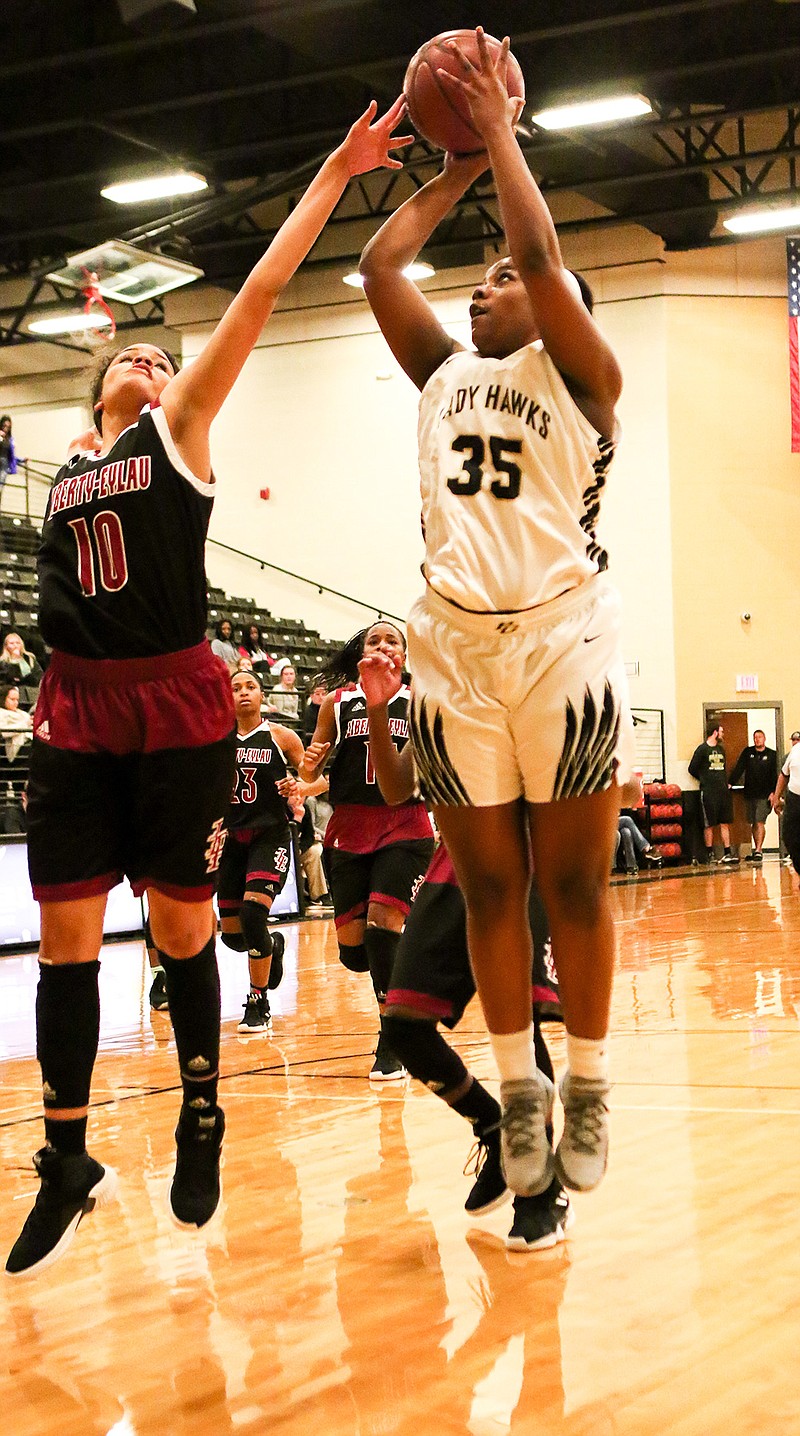 Lady Hawks' Keshawn Davis jumps up to take a shot while being guarded by Lady Leopards' Kyla Coston on Tuesday at Pleasant Grove High School.