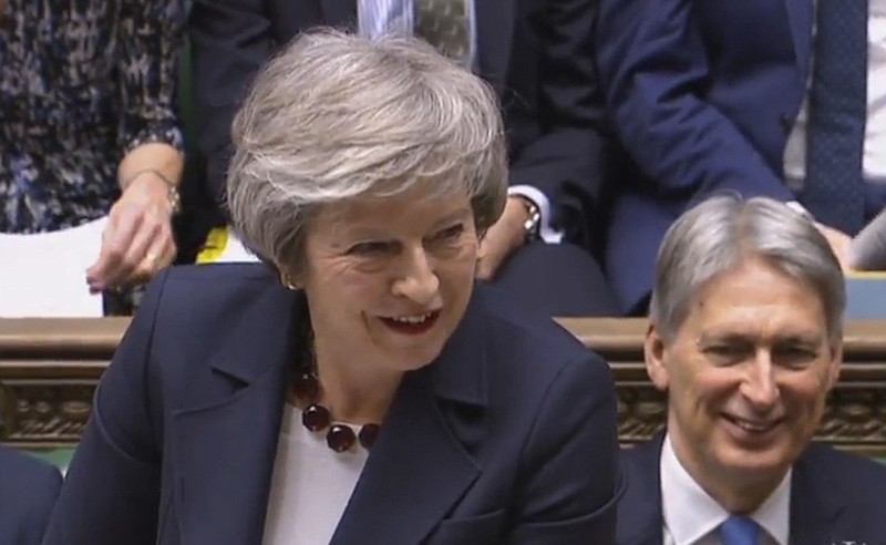 In this grab taken from video, Britain's Prime Minister Theresa May smiles during Prime Minister's Questions in the House of Commons, London, Wednesday, Jan. 9, 2019.  The British government brought its little-loved Brexit deal back to Parliament on Wednesday, a month after postponing a vote on the agreement to stave off near-certain defeat. (House of Commons/PA via AP)