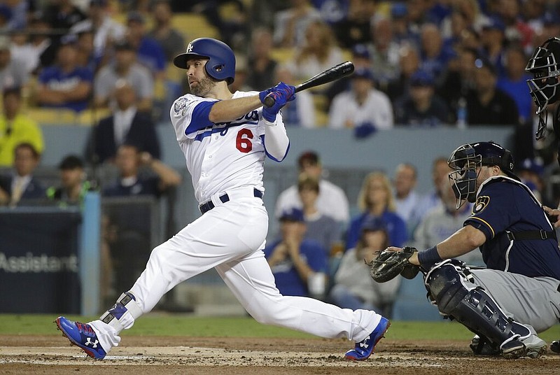 In this Oct. 16, 2018, file photo, Los Angeles Dodgers' Brian Dozier hits an RBI single during the first inning of Game 4 of the National League Championship Series baseball game against the Milwaukee Brewers, in Los Angeles.