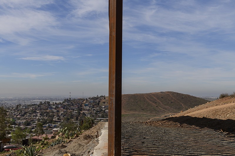 FILE - This Saturday, Dec. 22, 2018 file photo shows Tijuana, Mexico, left, and San Diego, Calif., separated by a U.S. border fence. The partial government shutdown which started in December 2018 has furloughed hundreds of thousands of government employees and halted services that aren’t deemed essential, including, in many instances, the immigration courts overseen by the Justice Department. (AP Photo/Daniel Ochoa de Olza)