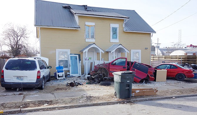 The front yard of a duplex at 212 and 216 E. Sixth St. in Fulton is filled with debris, including two mini vans  one with its engine removed and laying on the gravel next to a discarded tire. A white PVC toilet sits alongside the white van, also in disrepair, and a trailer load of debris blocks the west-side driveway. Damage to the dwelling's roof was caused by a late November attic fire. Trial dates for the owner of the dwelling are scheduled to be set Monday in criminal matters with which he is charged.