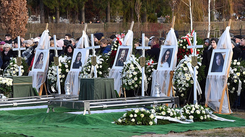 Pictures of five girls who died in an entertainment escape room fire last week, during their joint burial at a cemetery in Koszalin, northern Poland, on Thursday, Jan. 10, 2019. They died from carbon monoxide inhalation when a fire broke out next to the locked room where they were celebrating a birthday.(AP Photo)