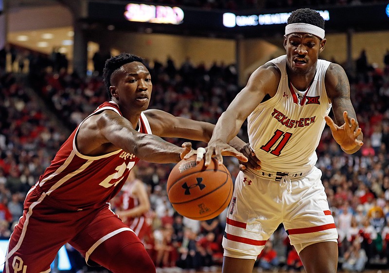 Oklahoma's Kristian Doolittle (21) and Texas Tech's Tariq Owens (11) reach out for the ball during the first half of an NCAA college basketball game Tuesday, Jan. 8, 2019, in Lubbock, Texas. (AP Photo/Brad Tollefson)