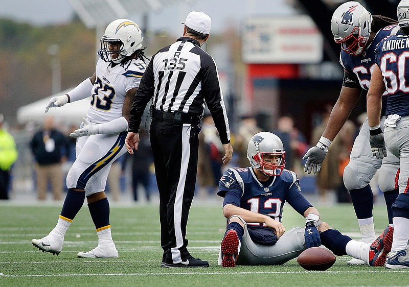 In this Oct. 29, 2017, file photo, Los Angeles Chargers defensive end Darius Philon, left, celebrates after sacking New England Patriots quarterback Tom Brady (12) during the second half of an NFL football game, in Foxborough, Mass. The Chargers held Tom Brady and New England to just one touchdown in four red zone trips in last year's game. After flummoxing Baltimore last week, Gus Bradley is hoping to come up with another successful game plan this week. (AP Photo/Steven Senne, File)