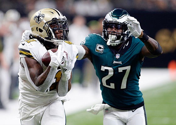 Saints running back Alvin Kamara pulls in a touchdown reception behind Eagles safety Malcolm Jenkins during the second half of a game this season in New Orleans.