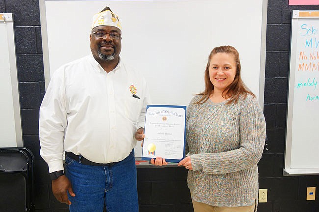 Charles Williams, left, chair of the Fulton VFW's scholarship program, presents Fulton Middle School teacher Melody Hapner with a Teacher of the Year award. The award recognizes teachers who work to promote patriotism and respect for veterans.