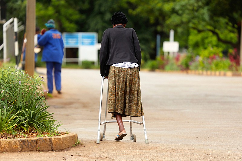 In this Jan. 10, 2019, photo, a woman makes her way to Parirenyawatwa Hospital in Harare, Zimbabwe. A doctors strike in Zimbabwe has crippled a health system that was already in intensive care from neglect. It mirrors the state of affairs in a country that was full of promise a year ago with the departure of longtime leader Robert Mugabe but now faces economic collapse.(AP Photo/Tsvangirayi Mukwazhi)