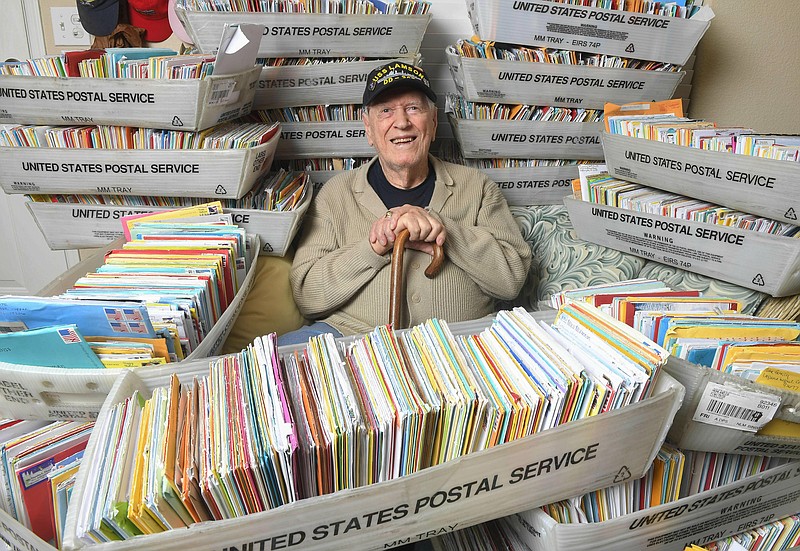 In this Tuesday, Jan. 8, 2019 photo, Duane Sherman, 96, poses at home with a small fraction of the 50,000 birthday cards he's received after his daughter's social media request for people to send him cards to cheer him up on his birthday went viral in Fullerton, Calif.  (Kevin Sullivan/The Orange County Register via AP)