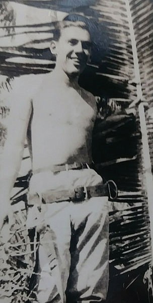 C.B. Smith is pictured in 1945 wearing a harness he used to scale coconut trees when maintaining a telephone exchange for the Seabees in the South Pacific.