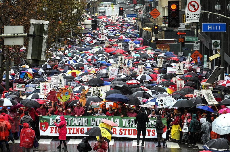 Thousands of teachers and supporters hold signs in the rain during a rally Monday, Jan. 14, 2019, in Los Angeles. Tens of thousands of Los Angeles teachers went on strike Monday for the first time in three decades after contract negotiations failed in the nation's second-largest school district, but schools stayed open with the help of substitutes and district officials said students were learning. (AP Photo/Ringo H.W. Chiu)