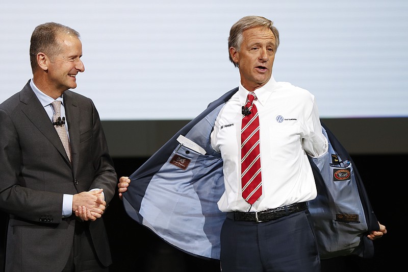 Dr. Herbert Diess, CEO, Volkswagen AG, left, watches Bill Haslam, Governor of Tennessee show his shirt during media previews for the North American International Auto Show in Detroit, Monday, Jan. 14, 2019. (AP Photo/Paul Sancya)