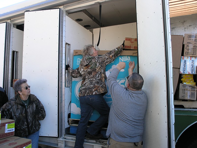 <p>Danisha Hogue/News Tribune</p><p>Wilma Distler reaches inside the Cole County Mobile Food Pantry truck to unload items for distribution at its Russellville stop Jan. 8.</p>