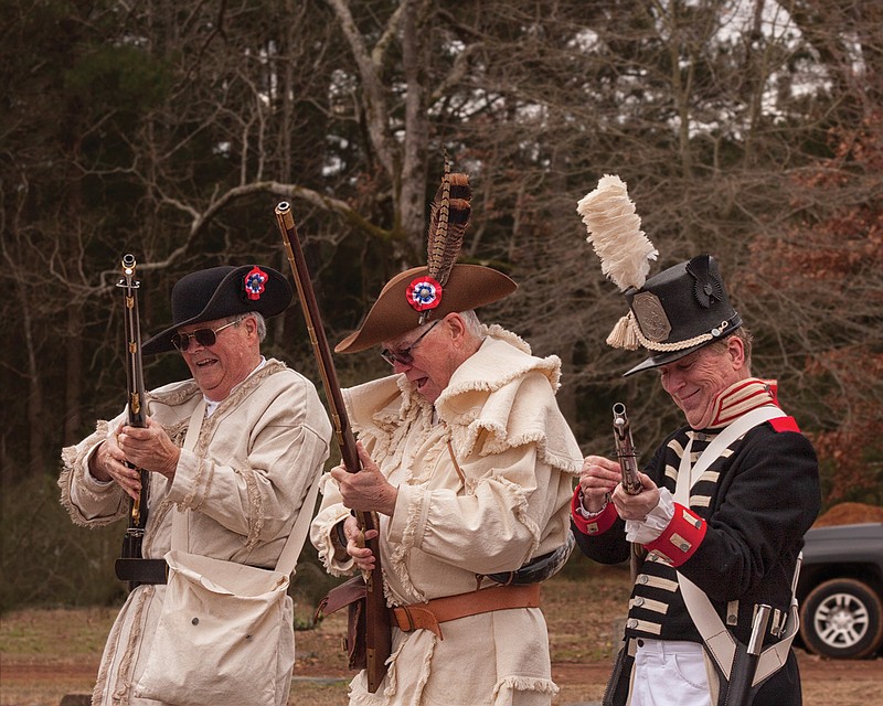 Members of the Sons of the American Revolution laugh Saturday after a gust of wind thwarted a volley in honor of John Bluford Endsley, a veteran of the War of 1812. Endsley, born in 1790, settled near Atlanta, Texas, in the 19th century and is buried at Beech Creek Cemetery in Cass County. Historical groups and descendants gathered Saturday to honor the veteran with two markers, which were placed at his headstone.  (Staff photo by Danielle Dupree)
