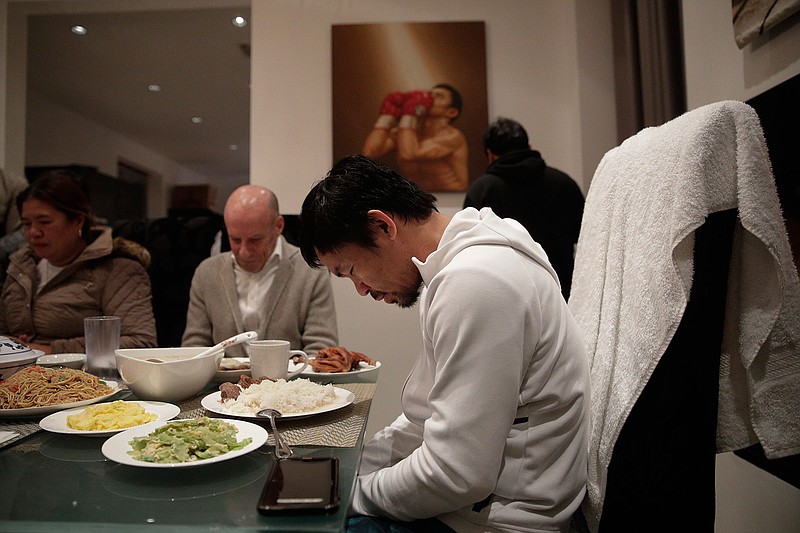 Boxer Manny Pacquiao prays before breakfast at his home following his morning run Monday, Jan. 14, 2019, in Los Angeles. Breakfast at Manny Pacquiao's house began with a silent prayer, followed by more silence around the big dining room table as his entourage waited for the fighter to take the first bite. (AP Photo/Jae C. Hong)