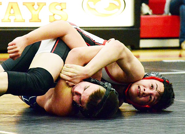 Jefferson City's Christian Strope tries to roll Helias' Gage Locke onto his back during their match at 120 pounds in Wednesday's dual at Fleming Fieldhouse.
