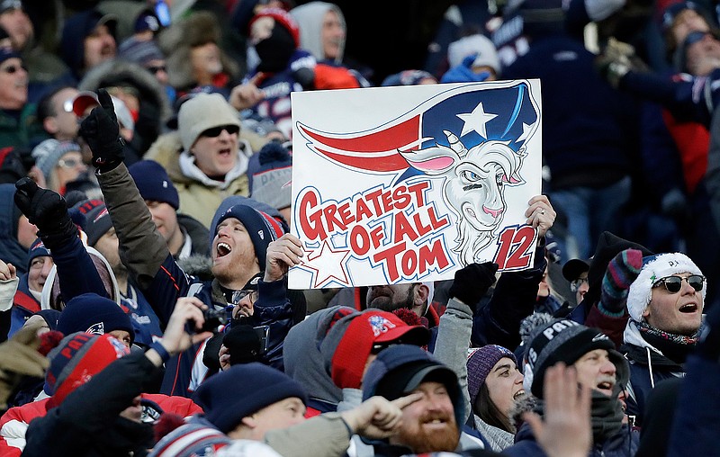 Fans cheer and hold a sign referring to New England Patriots quarterback Tom Brady during the second half of an NFL divisional playoff football game between the Los Angeles Chargers and the Patriots, Sunday, Jan. 13, 2019, in Foxborough, Mass. (AP Photo/Elise Amendola)
