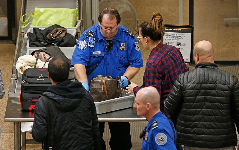 A TSA worker helps passengers at the Salt Lake City International Airport, Wednesday, Jan., 16, 2019, in Salt Lake City. The government shutdown has generated an outpouring of generosity to TSA agents and other federal employees who are working without pay. In Salt Lake City, airport officials treated workers from the TSA, FAA and Customs and Border Protection to a free barbecue lunch as a gesture to keep their spirits up during a difficult time. (AP Photo/Rick Bowmer)