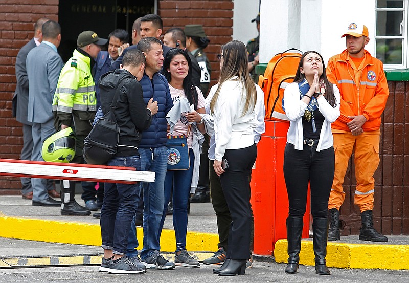 Family members of victims of a bombing gather outside the entrance to the General Santander police academy where the bombing took place in Bogota, Colombia, Thursday, Jan. 17, 2019. (AP Photo/John Wilson Vizcaino)