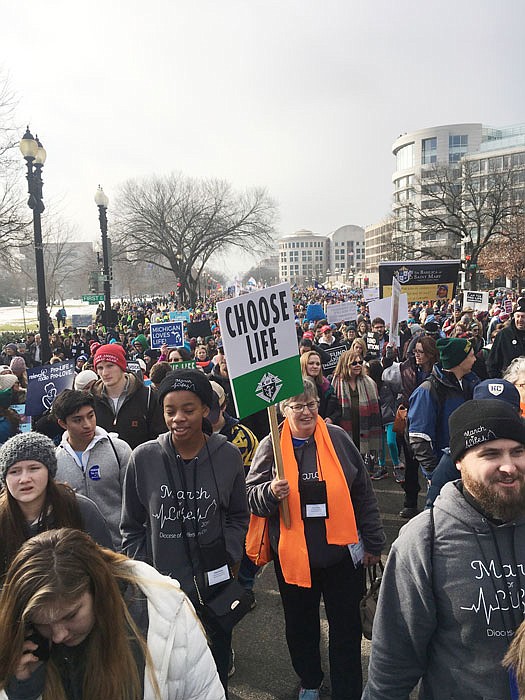 Phyllis Emmel (wearing an orange scarf), from Immaculate Conception Parish in Jefferson City, holds a "Choose Life" sign as she approaches the U.S. Capitol from the northwest Friday with fellow members of the Diocese of Jefferson City's group and others who traveled to Washington, D.C., for the 2019 March for Life. 