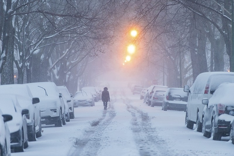 A woman walks down Glenlake Avenue towards North Clark Street as a winter storm batters Chicago, Saturday, Jan. 19, 2019, in Chicago. (Tyler LaRiviere/Chicago Sun-Times via AP)