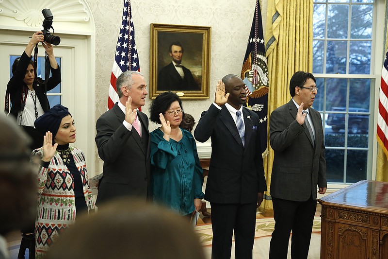 The five people being naturalized as American citizen, take the oath of allegiance in the Oval Office of the White House, in Washington, Saturday, Jan. 19, 2019. (AP Photo/Alex Brandon)