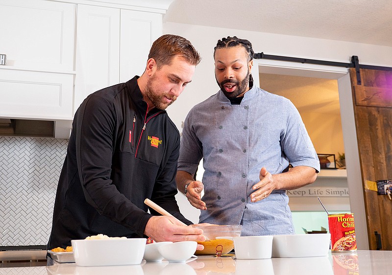 In a photo provided by Hormel Foods, Minnesota Vikings wide receiver Adam Thielen, left, and chef Kenneth Temple prepare a Minnesota-inspired chili dip Jan. 15, 2019, in Austin, Minn. "The beautiful thing about it is chili and football go hand in hand," Temple says, noting Hormel was a partner with the NFL as far back at the 1950s. "At tailgates or with friends at a viewing party or wherever, it is easy to accommodate a larger crowd." (Hormel Foods via AP)