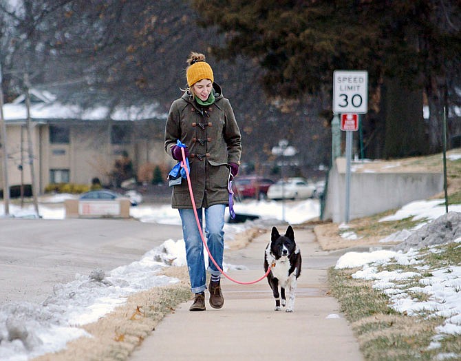 Kaylin Boeckman walks with her dog, Lucy, on Saturday along Main Street. Without the predicted snow in the way, the pair were able to brave the cold to get some exercise.