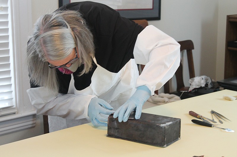 Diane McKinney, of the Missouri State Archives, opens the materials of a time capsule discovered by the Farmer Holding Company in November 2018. Grandchildren and great-grandchildren of workers who helped construct the old St. Mary's Hospital informed the company and the Historic City of Jefferson of the rumored capstone.