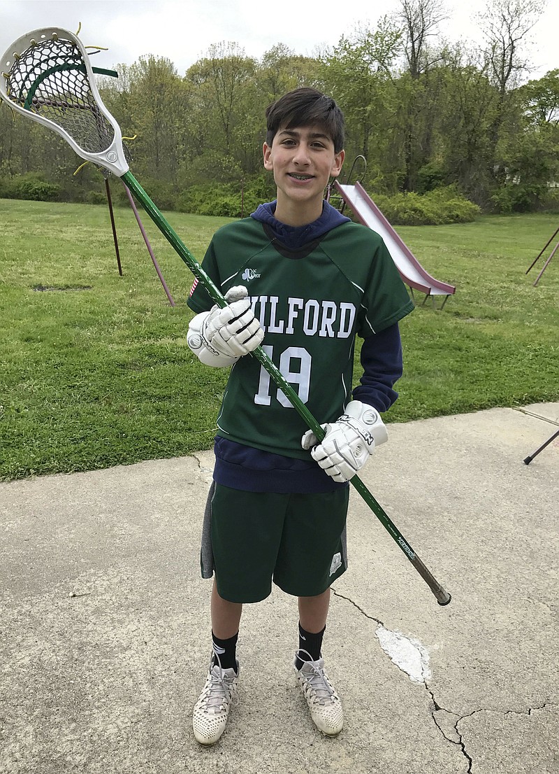 This 2017 photo provided by Mike Song shows his son Ethan Song posing in his lacrosse outfit in their hometown of Guilford, Conn. Ethan Song accidentally shot himself in the head with a handgun owned by his friend's father on Jan. 31, 2018 when he was 15. His death has spurred his parents to advocate for tougher federal and state laws on safe gun storage. Versions of “Ethan’s Law” were introduced this month in the U.S. Senate and Connecticut House of Representatives. They would require gun owners to take steps to prevent unauthorized users from accessing their weapons. (Mike Song via AP)