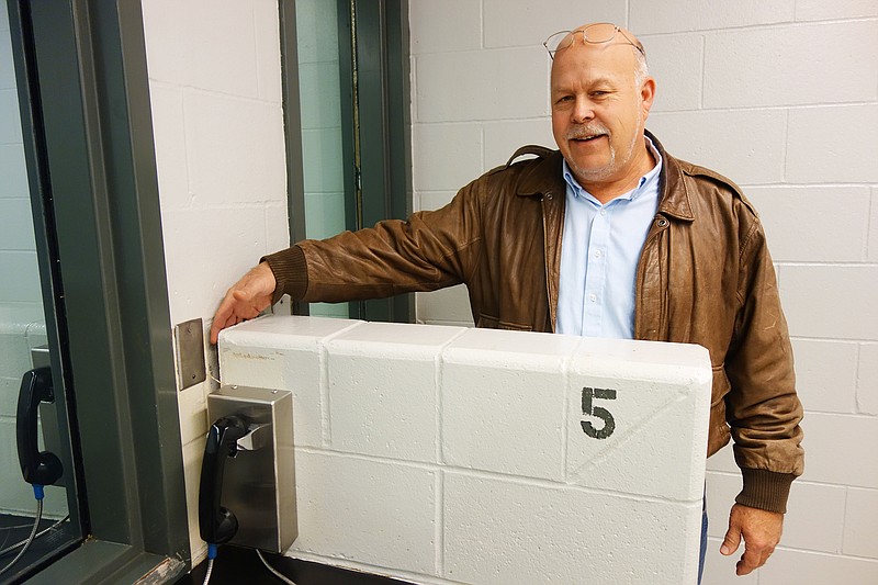 <p>Helen Wilbers/FULTON SUN</p><p>Gary Jungermann, Callaway County Presiding Commissioner, demonstrates the width of a crack between a partition and the wall in the Callaway County Jail’s visitation room. The jail’s foundations have been settling, causing cracks and other issues.</p>
