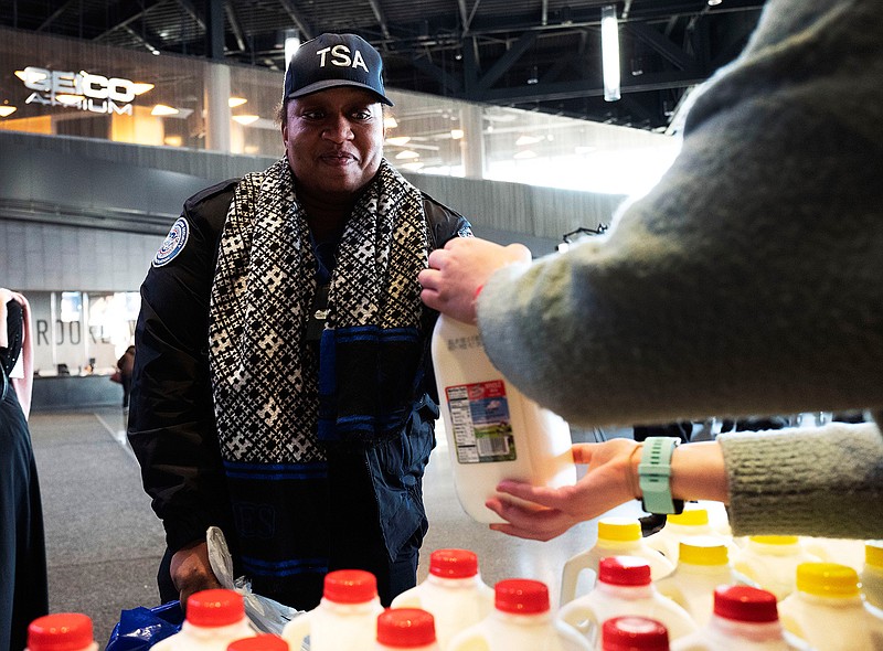 TSA worker Elizabeth Ford is given a bottle of milk at a food bank for government workers affected by the shutdown, Tuesday, Jan. 22, 2019, in the Brooklyn borough of New York. (AP Photo/Mark Lennihan)