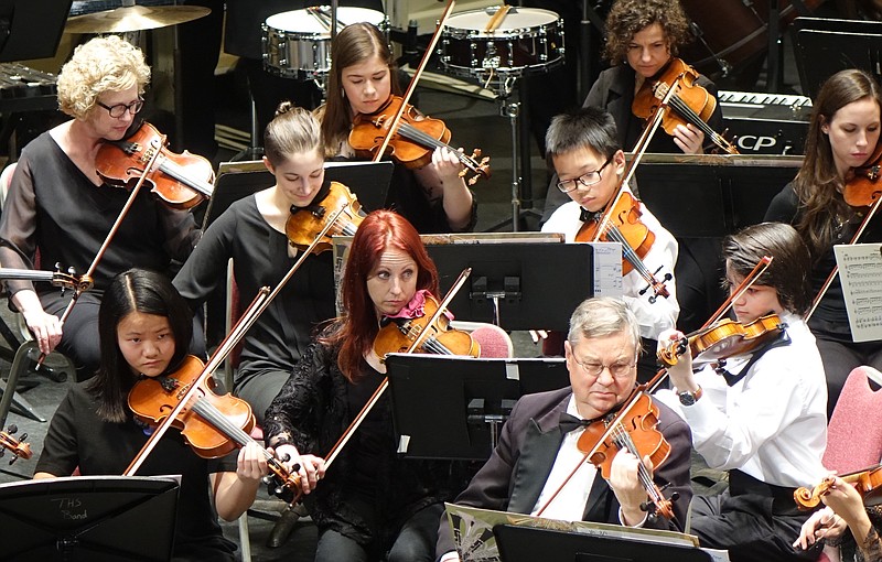 Playing side-by-side with the adult violinists of the Texarkana Symphony Orchestra are Clare Wong, left front row, and her brother Vincent, center right. Their teacher, Andrea Finley, is in the upper-left corner.