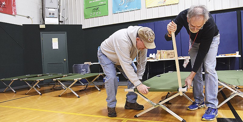 The American Red Cross set up temporary shelter Monday at Union Hill Baptist Church to house people who were displaced after a fire overnight destroyed a 30-unit apartment complex on Evergreen Drive in Holts Summit. John Mathews, left, and Harry Fairman joined efforts to set up cots for emergency bedding in the church's gymnasium.
