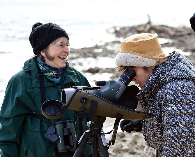 Kris Christopher, with the assistance of volunteer Anne Hutton, left, and other visitors at the Marion Access on the Missouri River, look for eagles Saturday using high powered lenses to spot the elusive birds during Eagle Days, hosted by Runge Nature Center. The event was sponsored by the Missouri Department of Conservation.