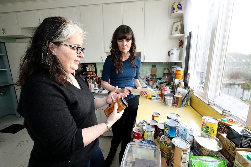 Food waste expert Jill Lightner, left, discusses what to keep and what to throw away with Bethany, center. Bethany Jean Clement cleans out her kitchen cupboards with the help of food waste expert Jill Lightner, getting in-depth about what you really should and shouldn't throw away. Photos taken Jan. 11, 2019 at Bethany's home. (Greg Gilbert/Seattle Times/TNS)