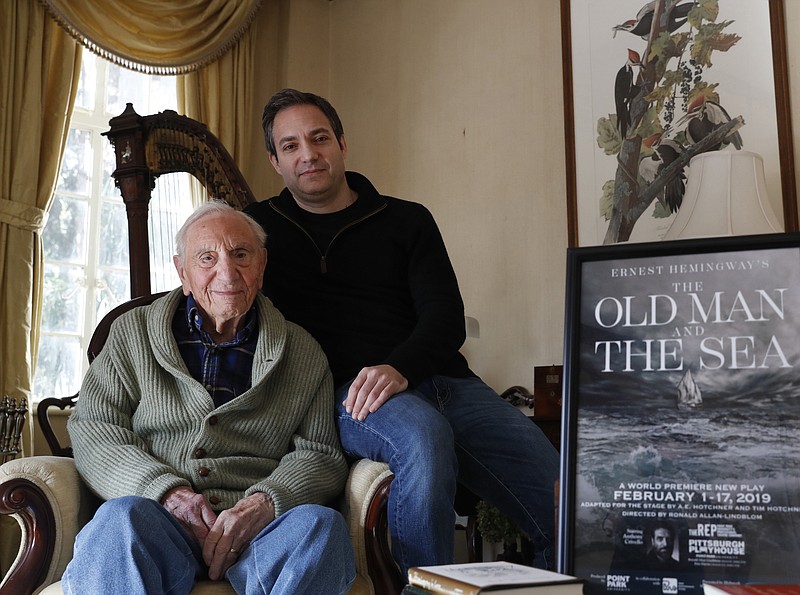 Ernest Hemingway's close friend and biographer A.E. Hotchner, left, poses for a photograph with his son Tim Hotchner, Tuesday, Jan. 22, 2019, in the Hotchner family home in Westport, Conn. When the 1958 film adaptation "The Old Man and the Sea" hit theaters, Ernest Hemingway told his close friend, the senior Hotchner, that he hated it and urged his writer pal to do his own adaptation someday. Now 101, and with Tim's help, Hotchner has finally completed Hemingway's request. Their stage adaptation of "The Old Man and the Sea" is set to premiere in Pittsburgh on Feb. 1. (AP Photo/Kathy Willens)